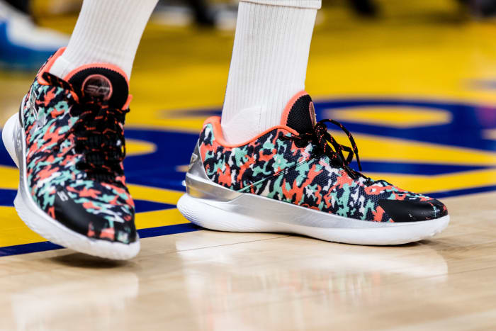 View of black, green, and orange Curry shoes.